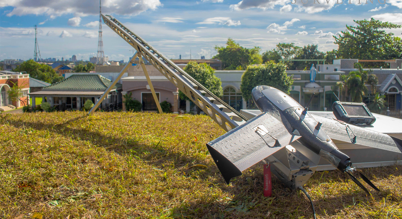 RASA fixed-wing survey UAV on a launch catapult with the Manila skyline behind